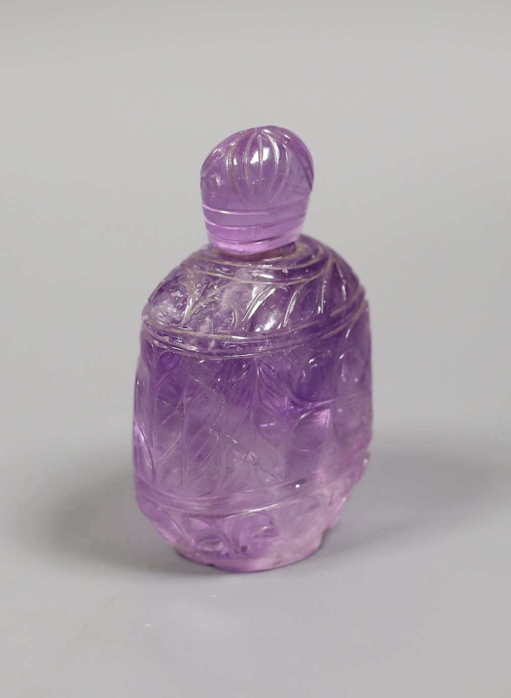 A carved amethyst quartz scent bottle and stopper, 9.5 cms high